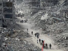 Gaza supera los 70 mil muertos: una guerra que erosiona a toda una sociedad Imagen de edificios destruidos en Gaza, con civiles caminando entre escombros, representando la devastación humanitaria provocada por más de dos años de guerra.