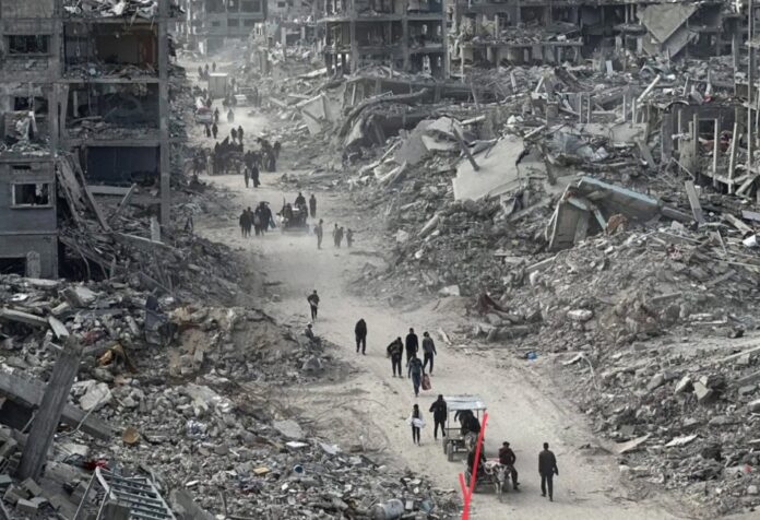 Imagen de edificios destruidos en Gaza, con civiles caminando entre escombros, representando la devastación humanitaria provocada por más de dos años de guerra.