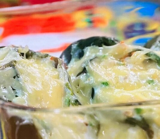 Chiles rellenos de flor de calabaza, elote y calabaza Chiles poblanos rellenos de flor de calabaza, elote y calabaza, servidos como platillo principal de cocina mexicana tradicional.