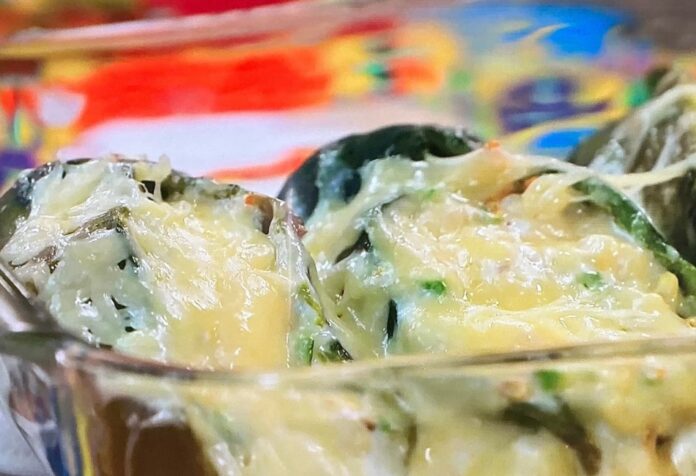 Chiles rellenos de flor de calabaza Chiles poblanos rellenos de flor de calabaza, elote y calabaza, servidos como platillo principal de cocina mexicana tradicional.