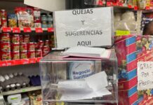 Escuchar también vende: la comunicación como ventaja invisible del pequeño comercio Caja de sugerencias y quejas colocada en el mostrador de una frutería, rodeada de productos, como muestra de comunicación directa entre comerciantes y clientes.