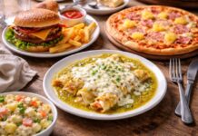 ¿Las enchiladas suizas son de Suiza? Mesa de madera con enchiladas suizas, hamburguesa con papas, pizza hawaiana y ensalada rusa, representando platillos con nombres de países que no siempre coinciden con su origen.