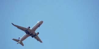 Advertencia de la FAA no afecta el espacio aéreo mexicano Avión comercial volando sobre el océano al atardecer, representando rutas aéreas internacionales y la normalidad de la operación aérea pese a advertencias técnicas.