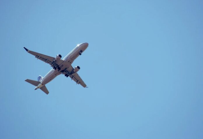Avión comercial volando sobre el océano al atardecer, representando rutas aéreas internacionales y la normalidad de la operación aérea pese a advertencias técnicas.