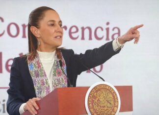 Sheinbaum presenta reforma electoral: elimina listas plurinominales y reduce gasto Claudia Sheinbaum habla desde el podio presidencial durante la conferencia matutina, señalando al público mientras expone la propuesta de reforma electoral.