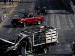 Refuerzan seguridad y medidas preventivas tras operativo contra líder del CJNG Camioneta incendiada en una vialidad urbana acordonada por autoridades, imagen que ilustra los bloqueos y disturbios registrados tras el operativo federal contra el líder del CJNG.