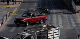 Refuerzan seguridad y medidas preventivas tras operativo contra líder del CJNG Camioneta incendiada en una vialidad urbana acordonada por autoridades, imagen que ilustra los bloqueos y disturbios registrados tras el operativo federal contra el líder del CJNG.