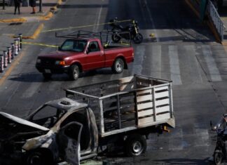 Refuerzan seguridad y medidas preventivas tras operativo contra líder del CJNG Camioneta incendiada en una vialidad urbana acordonada por autoridades, imagen que ilustra los bloqueos y disturbios registrados tras el operativo federal contra el líder del CJNG.