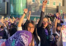 8M en México: por qué marchan las mujeres y qué caminos hay para cambiar la realidad Multitud de mujeres marchando durante el 8M con pañuelos morados y el puño en alto en señal de protesta y solidaridad.