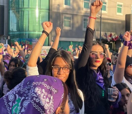 8M en México: por qué marchan las mujeres y qué caminos hay para cambiar la realidad Multitud de mujeres marchando durante el 8M con pañuelos morados y el puño en alto en señal de protesta y solidaridad.