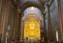 ¿Cómo se construyeron los templos monumentales de México? La historia detrás de su grandeza Interior de un templo barroco en Morelia, Michoacán, con bóvedas y muros completamente decorados, retablos dorados y un altar central iluminado con la imagen de la Virgen de Guadalupe.