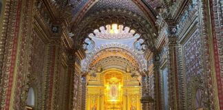 ¿Cómo se construyeron los templos monumentales de México? La historia detrás de su grandeza Interior de un templo barroco en Morelia, Michoacán, con bóvedas y muros completamente decorados, retablos dorados y un altar central iluminado con la imagen de la Virgen de Guadalupe.