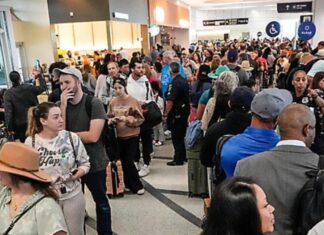Se paraliza parcialmente gobierno federal de EE.UU. por la falta de un acuerdo presupuestario Multitud de pasajeros haciendo largas filas dentro de un aeropuerto en Estados Unidos, con áreas saturadas y personal limitado, en un contexto de afectaciones operativas por falta de pago a trabajadores federales.