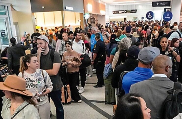 Se paraliza parcialmente gobierno federal de EE.UU. por la falta de un acuerdo presupuestario Multitud de pasajeros haciendo largas filas dentro de un aeropuerto en Estados Unidos, con áreas saturadas y personal limitado, en un contexto de afectaciones operativas por falta de pago a trabajadores federales.