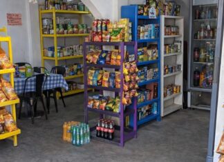 Las tienditas no solo sobreviven, sino que dominan el consumo cotidiano Tienda de abarrotes de barrio con productos básicos, refrescos y botanas exhibidos al frente.