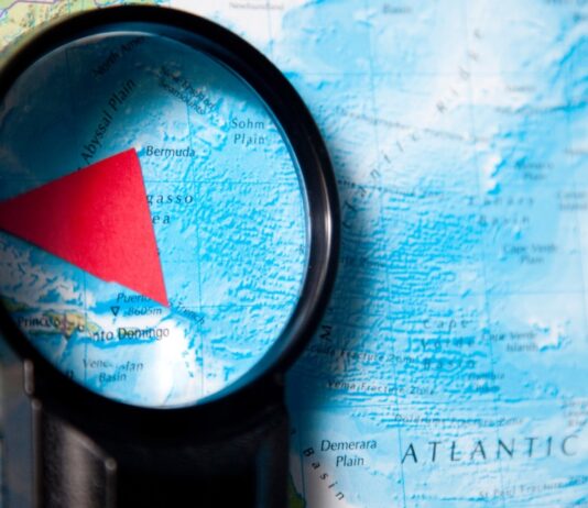 El Triángulo de las Bermudas: la ciencia entrando al territorio del mito Mapa del océano Atlántico observado con una lupa que resalta el Triángulo de las Bermudas mediante una figura triangular roja.