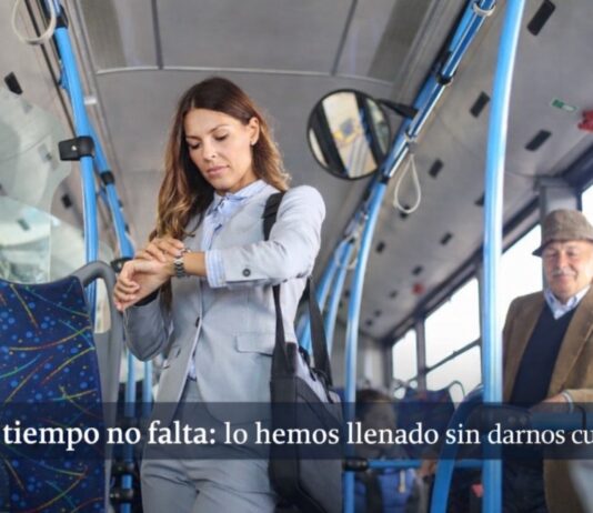 La vida cotidiana bajo presión: por qué sentimos que nunca tenemos tiempo (aunque sí lo tenemos) Mujer de pie dentro de un autobús urbano revisando su reloj, rodeada de otros pasajeros en un entorno cotidiano de transporte público.