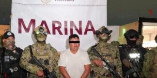 Capturan a “El Jardinero”, operador clave del CJNG en operativo de inteligencia Hombre detenido con los ojos cubiertos, custodiado por elementos armados de la Marina y fuerzas de seguridad en México durante su presentación oficial.
