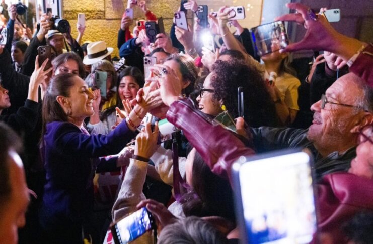 Sheinbaum llega a Barcelona entre aplausos y celulares en alto: arranca su primer viaje europeo como presidenta Presidenta Claudia Sheinbaum saludando a una multitud de personas que la reciben con celulares y aplausos en Barcelona.