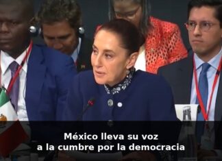 Sheinbaum en Barcelona: una voz que habla desde México ante el mundo Claudia Sheinbaum habla en un foro internacional en Barcelona, sentada frente a un micrófono, con la bandera de México visible a un costado.