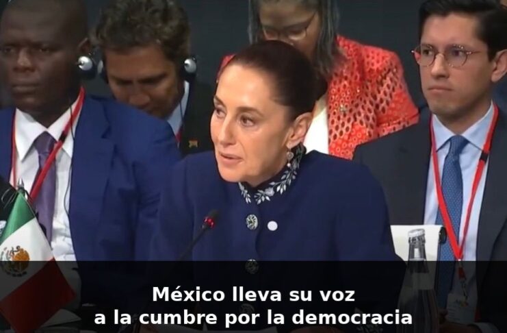 Sheinbaum en Barcelona: una voz que habla desde México ante el mundo Claudia Sheinbaum habla en un foro internacional en Barcelona, sentada frente a un micrófono, con la bandera de México visible a un costado.