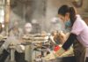 México registra una de las tasas de desempleo más bajas del mundo Mujer trabajando en una línea de producción industrial mientras opera maquinaria en un entorno de manufactura, con vapor y equipo de trabajo al fondo.