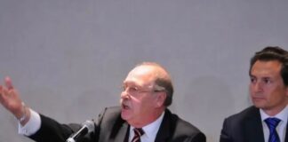 Francisco Javier Coello Trejo, el “Fiscal de Hierro” del México represor Francisco Javier Coello Trejo participa en una conferencia pública sentado junto a Emilio Lozoya Austin, exdirector de Pemex, frente a micrófonos y mesas de exposición.