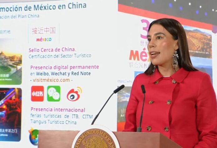 La secretaria de Turismo de México ofrece una conferencia sobre crecimiento del turismo internacional y estrategias de promoción hacia China, frente a una pantalla con información sobre plataformas digitales y certificaciones turísticas.
