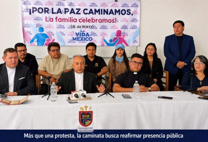 Rueda de prensa en Querétaro donde representantes católicos y evangélicos anuncian la caminata del 16 de mayo frente a un cartel con mensajes sobre paz y familia.