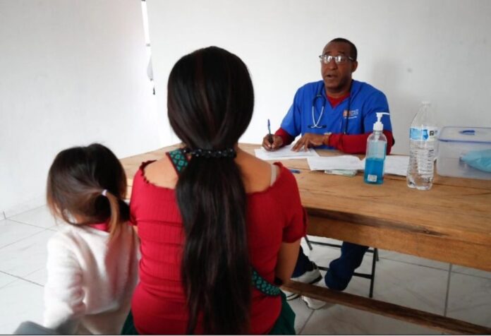 Médicos cubanos en Sinaloa Consulta médica en una unidad de salud rural de Sinaloa, donde un médico cubano atiende a una mujer y una menor de edad en una comunidad apartada.