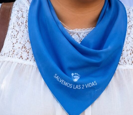 El límite del movimiento provida: ¿qué entiende exactamente por vida? Primer plano de una mujer portando un pañuelo azul con la frase “Salvemos las 2 vidas”, símbolo utilizado en movilizaciones provida en México.
