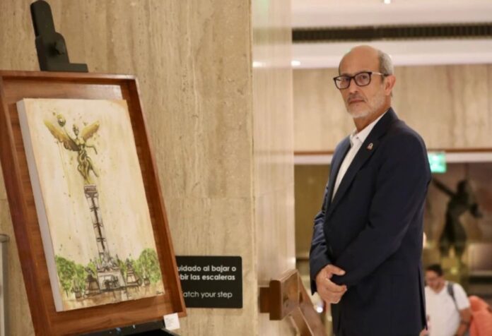 Presidente del Parlsmento Latinoamericano Rolando González Patricio, presidente del Parlamento Latinoamericano y Caribeño (Parlatino), de pie junto a una pintura exhibida en un edificio institucional durante una visita oficial a México.
