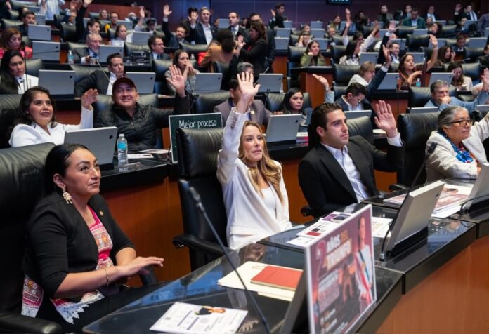 Legisladores levantan la mano durante una sesión del Senado de la República en la que se vota una reforma constitucional relacionada con la nulidad de elecciones por intervención extranjera.