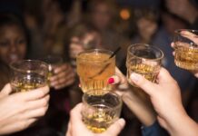 Jóvenes, alcohol y nuevas formas de divertirse Grupo de jóvenes brindando con bebidas alcohólicas durante una reunión nocturna, imagen que ilustra un artículo sobre el ocio juvenil y el consumo de alcohol en España y México.