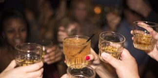 Jóvenes, alcohol y nuevas formas de divertirse Grupo de jóvenes brindando con bebidas alcohólicas durante una reunión nocturna, imagen que ilustra un artículo sobre el ocio juvenil y el consumo de alcohol en España y México.