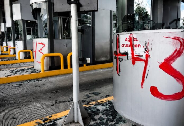 Cristales rotos Caseta de cobro de Tlalpan con cristales rotos, equipos dañados y pintas tras una protesta de normalistas de Ayotzinapa en junio de 2026.