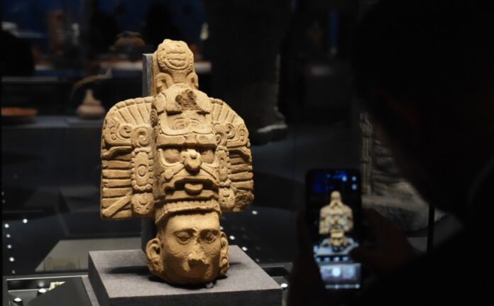 Escultura maya expuesta en el Museo de la Capital de Pekín durante la muestra internacional Maíz-Oro-Jaguar, visitada por público chino.