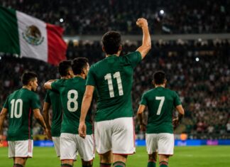 México ganó, pero la pregunta sigue siendo si convenció Futbolistas con camiseta verde y short blanco celebran en un estadio lleno mientras una bandera mexicana ondea al fondo.