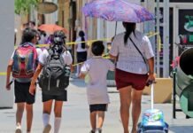 Detectar a tiempo el cáncer de piel puede salvar vidas: hasta 95% de los casos pueden curarse Madre y tres niños caminan bajo el sol en una calle urbana; uno de los adultos utiliza sombrilla para protegerse de la radiación solar durante una jornada de altas temperaturas.