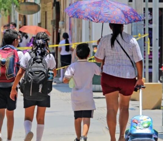 Detectar a tiempo el cáncer de piel puede salvar vidas: hasta 95% de los casos pueden curarse Madre y tres niños caminan bajo el sol en una calle urbana; uno de los adultos utiliza sombrilla para protegerse de la radiación solar durante una jornada de altas temperaturas.