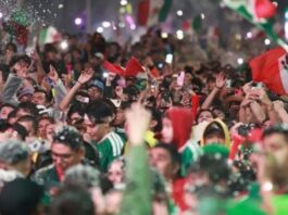 La alegría también necesita prudencia Multitud de aficionados mexicanos celebrando con banderas, luces y teléfonos durante festejos futboleros.