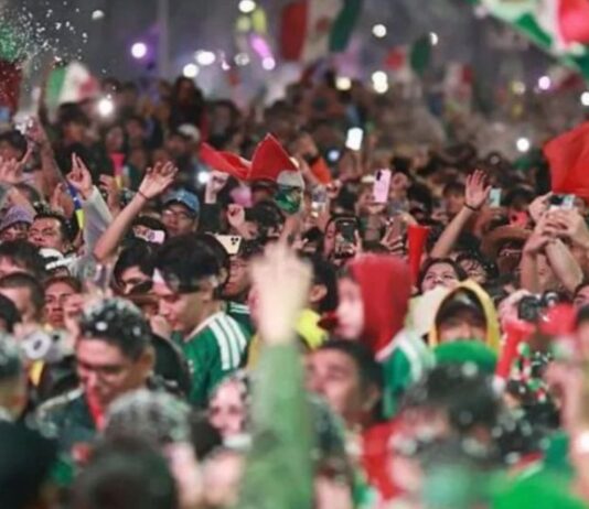 La alegría también necesita prudencia Multitud de aficionados mexicanos celebrando con banderas, luces y teléfonos durante festejos futboleros.