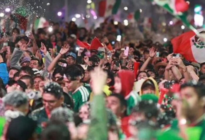 Alegría y tragedia en los festejos del mundial Multitud de aficionados mexicanos celebrando con banderas, luces y teléfonos durante festejos futboleros.