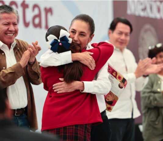 Zacatecas será el primer estado con becas desde primaria hasta universidad La presidenta Claudia Sheinbaum abraza a una estudiante durante un evento de entrega de becas en Zacatecas, acompañada por autoridades federales y estatales.