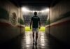 Dejemos de decir “sí se puede”, dejemos de soñar con el “¿Y si sí? Futbolista mexicano camina solo por el túnel de un estadio hacia una cancha iluminada, simbolizando la confianza, la preparación y la mentalidad ganadora antes de un partido.