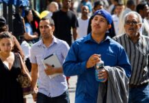 Los latinos tardan tres generaciones para sentirse típicamente estadounidenses Personas de origen hispano caminan por una calle de Estados Unidos, imagen que ilustra la diversidad de generaciones y experiencias de la comunidad latina.