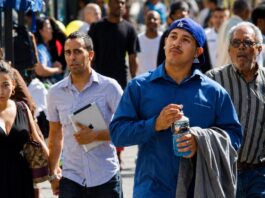 Los latinos tardan tres generaciones para sentirse típicamente estadounidenses Personas de origen hispano caminan por una calle de Estados Unidos, imagen que ilustra la diversidad de generaciones y experiencias de la comunidad latina.