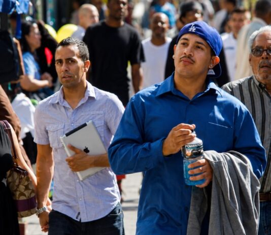 Los latinos tardan tres generaciones para sentirse típicamente estadounidenses Personas de origen hispano caminan por una calle de Estados Unidos, imagen que ilustra la diversidad de generaciones y experiencias de la comunidad latina.