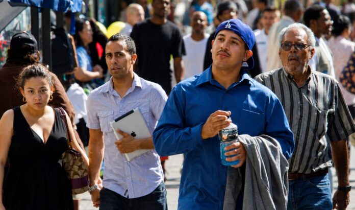 Latinos en Estados Unidos Personas de origen hispano caminan por una calle de Estados Unidos, imagen que ilustra la diversidad de generaciones y experiencias de la comunidad latina.