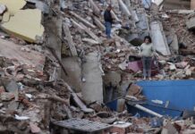 Delcy Rodríguez anuncia plan de recuperación tras los sismos y pide levantar sanciones a Venezuela Mujer de pie entre los escombros de edificios derrumbados por los terremotos en Venezuela, con estructuras colapsadas y labores de recuperación en el lugar.